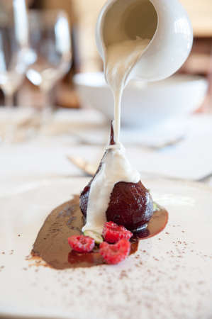 cream being poured onto a delicious poached pearの写真素材