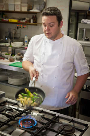 Chef sautes vegetables with intentional motion blurの写真素材