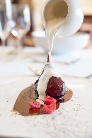cream being poured onto a delicious poached pearの写真素材