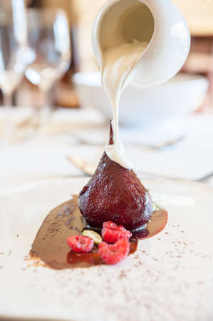 cream being poured onto a delicious poached pearの写真素材