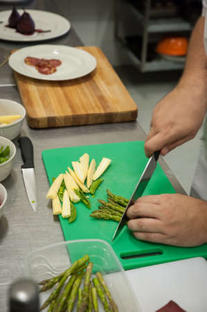 A chef prepares and plates food in a kitchenの写真素材