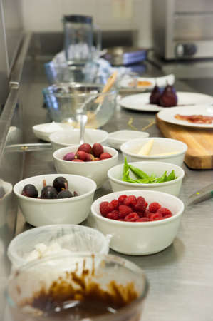 A chef prepares and plates food in a kitchenの写真素材