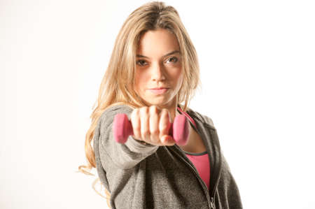 Attractive female fitness model isolated on a white background in sports wear with dumbells