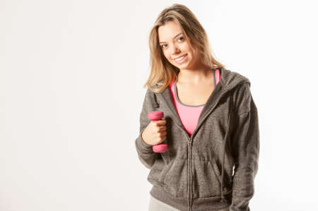 Attractive female fitness model isolated on a white background in sports wear with dumbellsの写真素材