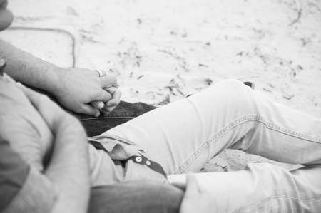 gay men lovingly embracing and cuddling on a beachの写真素材