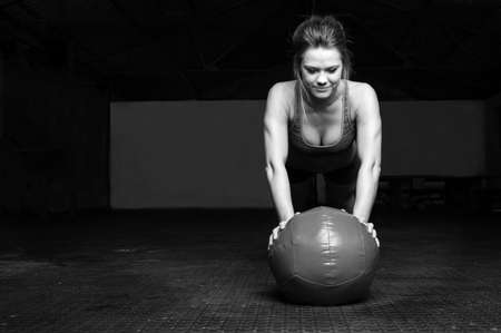 woman doing plank exercise on a ballの写真素材
