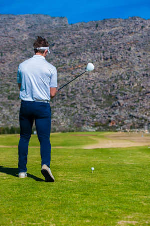 view of a golfer teeing off from a golf tee on a bright sunny day on a golf course in south africaの写真素材