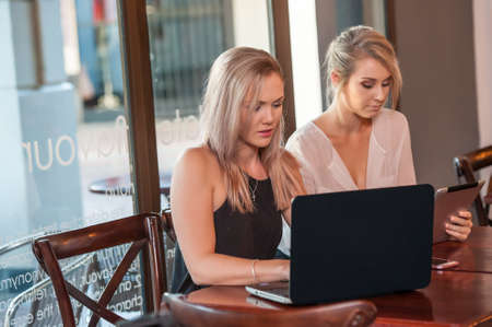 two blonde female having a business meeting in a coffee shopの写真素材