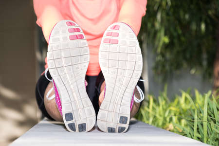 image of a female athlete stretching and recovering after a waork out in an urban setting