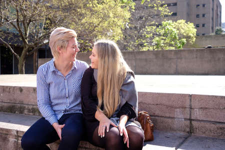 two lesbian gay women in their twenties enbrace in a city landscape in Cape Town, South Africaの写真素材