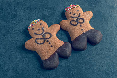 two ginger bread men on a dark slate backgroundの写真素材
