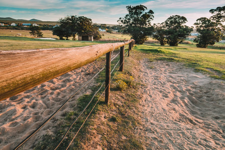 farm fence and sandy path in a rural setting at sunsetの写真素材