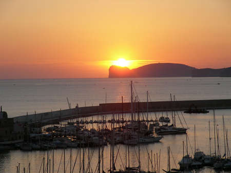 A becautiful sunset over the harbour in Alghero (Italy)の写真素材