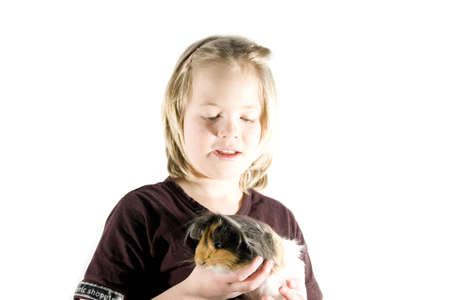 A girl and her guinea pig having fun in front of the cameraの写真素材
