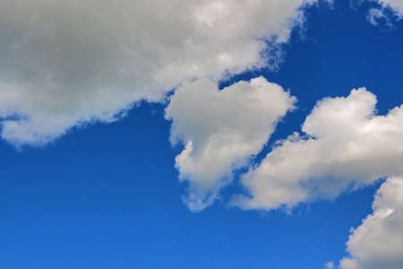 Bright blue sky with white cumulus cloudsの写真素材