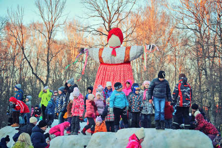 Traditional Maslenitsa Scarecrow on seeing Russian winter on last day of Shrovetide. Viewers awaiting initiation of ignition. Group of children standing at scarecrows, March 3, 2016, Tula, Russiaのeditorial素材