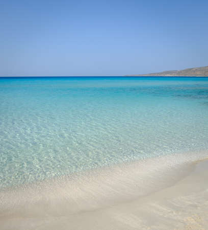 Idyllic perfect tropical white sandy beach and turquoise clear ocean water - summer vacation natural background with blue sunny sky. Simos beach in Elafonisos island in Greece.の写真素材