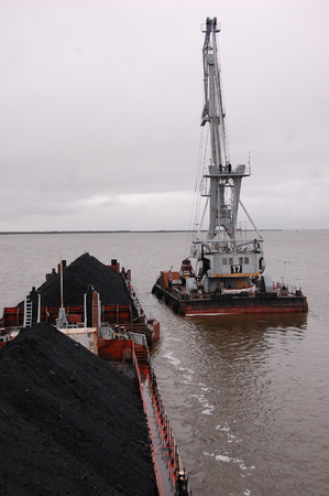 Cargo crane at platform near ship with coal, Kolyma river, Russiaのeditorial素材