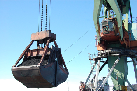 Dockside cargo crane loads coal at river port Kolyma, Yakutia, Russiaの写真素材