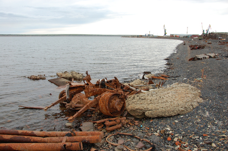 Old rusty abandoned metal vehicle parts at arctic sea coast, Pevek town, Chukotka, Russiaの写真素材