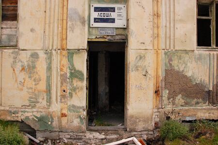 Old information sign above abandoned building entrance, Pevek town, Chukotka, Russiaの写真素材