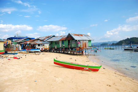 Boats at sand beach village coast with pier, Indonesiaの写真素材