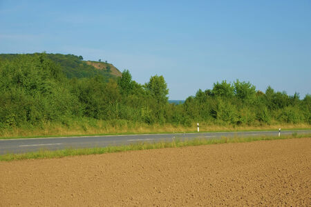 an empty running through farmland and forestsの写真素材