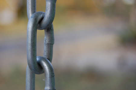 A closeup shot of a metal chain in the park with blurred backgroundの写真素材