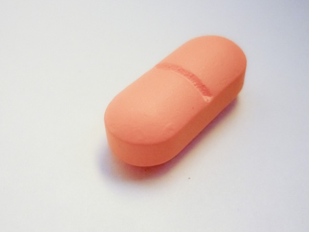 Orange pill in white background.の写真素材