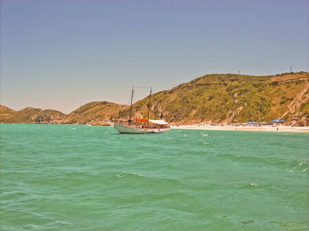 Small passenger boat in a beach of Buzios, Brasil, taken from another boat.のeditorial素材