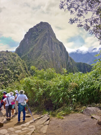 People watching a breathtaking view of the "Huayna Picchu" mountain from the "Machu Pichu Mountain" in the sacred city of incas in Peruのeditorial素材