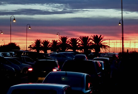 Beautiful sunset in a street full of cars in Punta de Este, the most famous seaside resort of Uruguayの写真素材