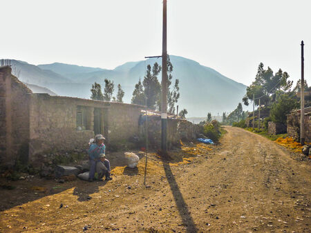 COLCA VALLEY AREQUIPA, PERU - APRIL 2014 - Mother and son wait out the bus in a spectacular view of the mountains in the Colca Valleyのeditorial素材