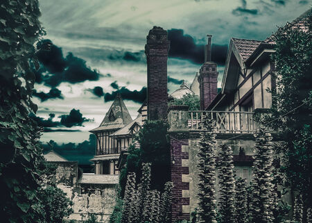 Dark scene night village digital manipulated and color edited photograpy of medieval houses with plants and trees around and cloudy sky in background.の写真素材
