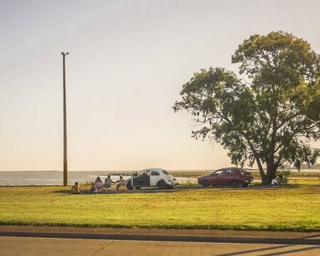 Group of people enjoying a nice day at the coast in the city of Montevideo, the capital of Uruguay.