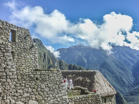 CUZCO, PERU, APRIL 2014 - Two tourist women exploring the ancient inca city of Machu Picchu in Peru.のeditorial素材