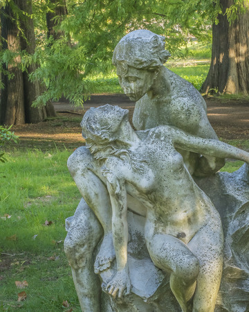 Front view of a couple about to kiss gray sculpture against trees and plants background taken in botanical garden of Montevideo, Uruguay.の写真素材