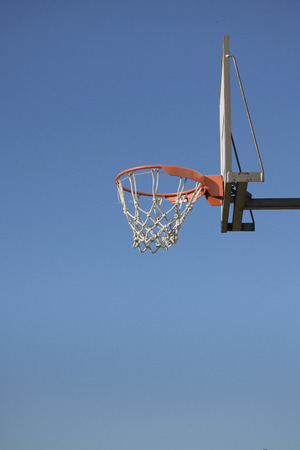 Low angle view outdoor basketball basket against clean blue sky.の写真素材
