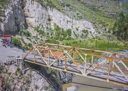 High angle view of rusty bridge surrounded by moutains andes range at a sunny day at Colca valley in the outsides of Arequipa city in Peru, South America.の写真素材