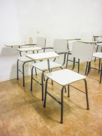 Perspective view of a bunch of empty classroom white chairs.の写真素材