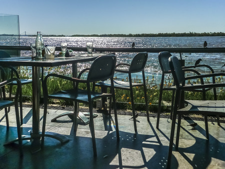 ROSARIO, ARGENTINA, JULY 2014 - Bunch of empty chairs and table in a restaurant in front of parana river in the city of Rosario, Argentina.のeditorial素材