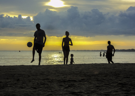 CANELONES, URUGUAY, FEBRAURY - 2015 - Family playing soccer at the beach with the sunset at the background in Atlantida, one of the most famous seaside resorts of Uruguay, in South Americaのeditorial素材