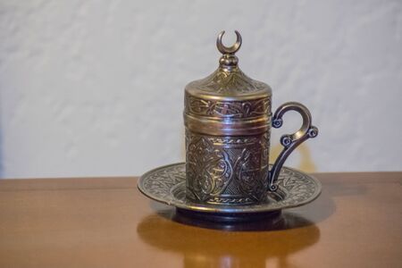 Beautiful decorated artwork turkish tea cup on a table and white wall background.の写真素材