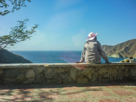 Colombian black woman enjoying a spectacular landscape view of the bay of Taganga, a famous caribbean watering place of Colombia, South America.の写真素材