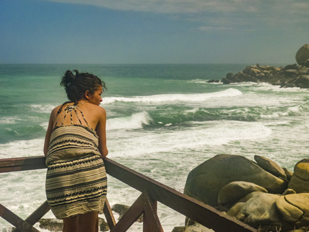 MAGDALENA, COLOMBIA, JANUARY - 2015 - Back view of young woman watching the view at Cabo San Juan beach, the most famous beach of tayrona park, a touristic protected area in the colombian northern caribbean regionのeditorial素材
