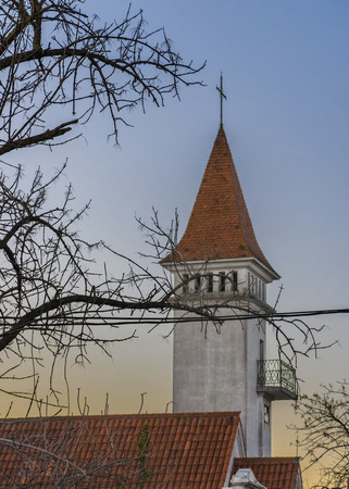 Urban scene at winter day depicting a tower church surrounded by branches against pale blue sky in Montevideo, Uruguay.の写真素材