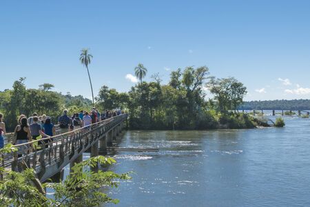PORT IGUAZU, ARGENTINA, MARCH - 2015 - Group of tourists crossing a bridge which goes to the famous devil throat falls at Iguazu park in argentinian border.のeditorial素材