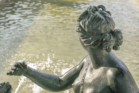 Back view classic style sculpture with water at background.の写真素材