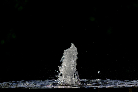 Close up photo water fountain against black background.の写真素材