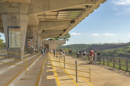FOZ DO IGUAZU, BRAZIL, APRIL - 2015 - Group of tourist crossing the installations of the Itaipu dam in the brazilian border.のeditorial素材